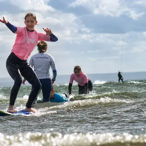 Élèves en cours de surf dans les vagues