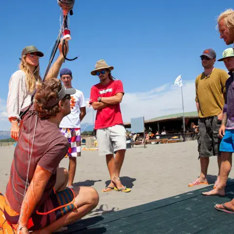 Briefing d'un groupe d'élèves sur la plage avant la leçon