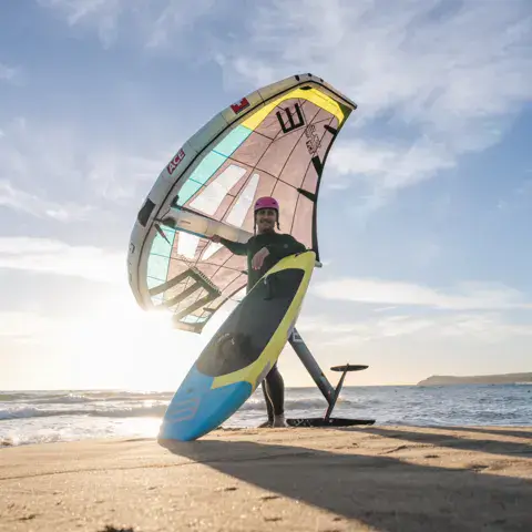Pratiquant de wing foil sur la plage