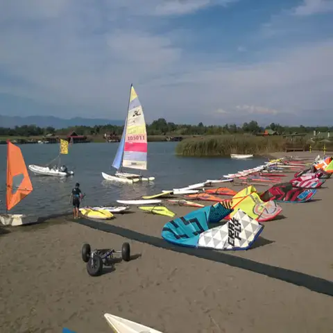 Matériel de windsurf, de kite et catamarans alignés sur la plage de la lagune