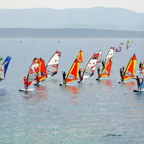 Une flottille de planches à voile colorées sur le lac