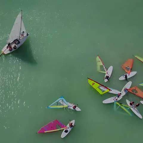 Vue aérienne d'un groupe de planches à voile et d'un voilier