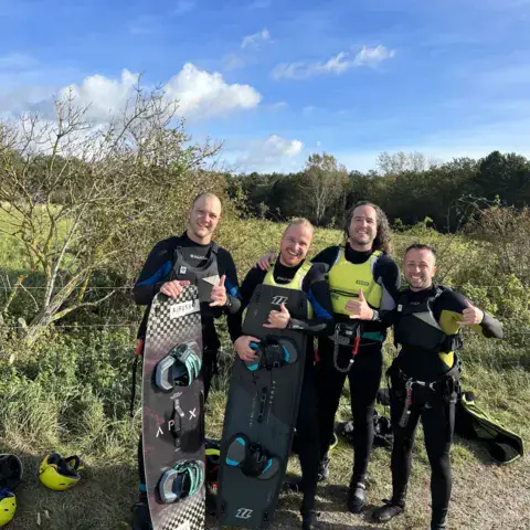 Élèves de kitesurf avec des planches sur la plage