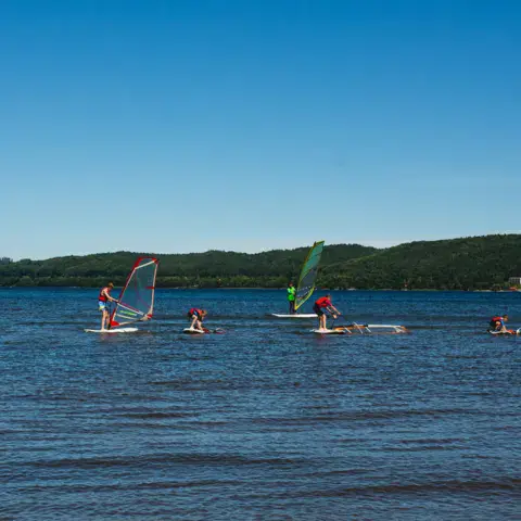 Groupe de windsurf sur le lac, un moniteur dans l'eau