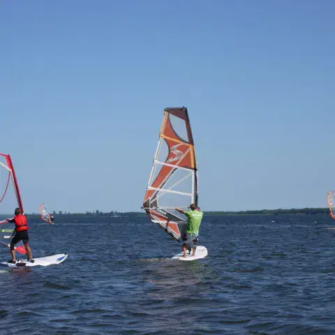 Véliplanchistes sur le lac sous un ciel bleu