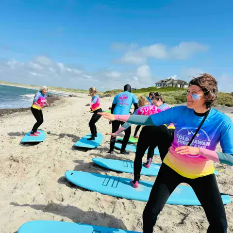 Exercice de passage debout sur la plage pendant un cours de surf