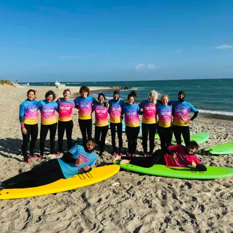 Classe de surf alignée sur la plage devant la mer du Nord
