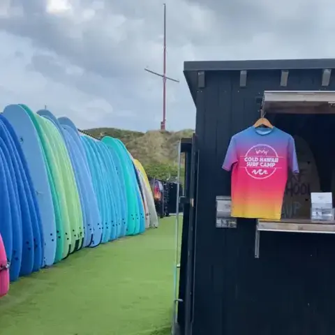 Planches de surf alignées à côté de la boutique du camp