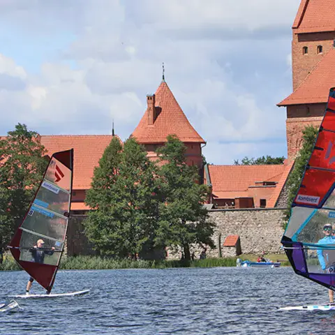 Planchistes sur le lac, château de Trakai en arrière-plan