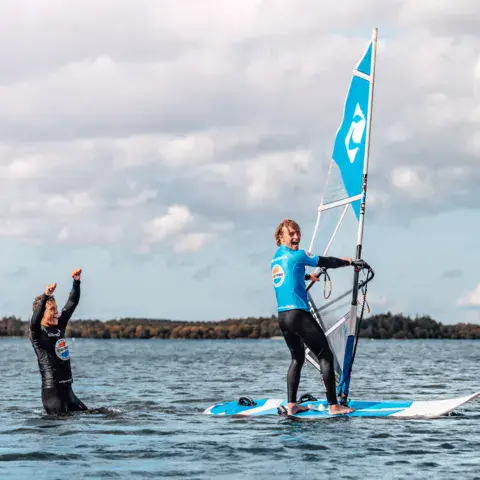 Cours de windsurf avec un moniteur sur un plan d'eau abrité
