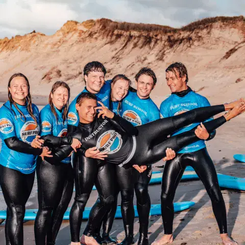 Groupe d'élèves en combinaison au pied des dunes