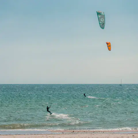 Kitesurfeurs au large d'une plage de sable