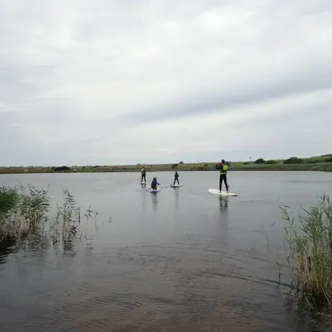 Sortie de paddle sur une lagune bordée de roseaux