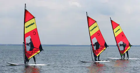 Planches à voile d'école sur l'eau