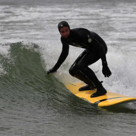 Surfeur en combinaison sur une vague