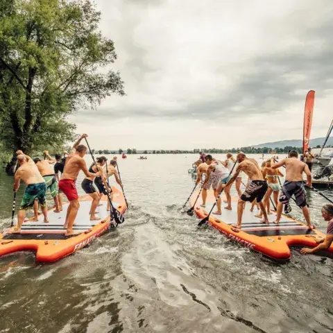 Groupe qui met à l'eau de grandes plateformes gonflables