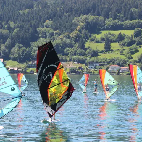 Groupe de windsurfeurs sur le lac