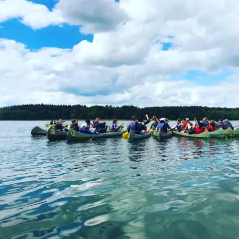Groupe en canoës sur un lac calme