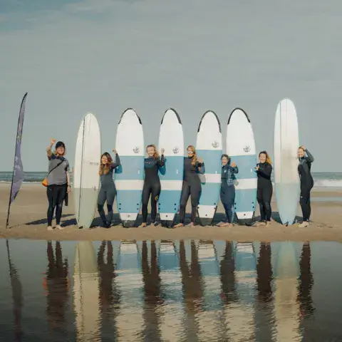 Groupe de surfeurs avec leurs planches alignées sur la plage