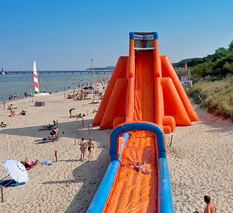 Plage de sable avec un toboggan gonflable, vue du ciel