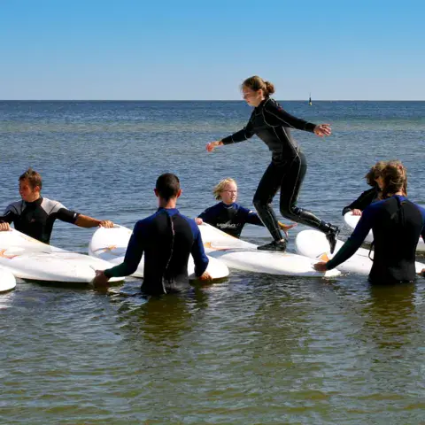 Groupe sur des planches dans l'eau peu profonde