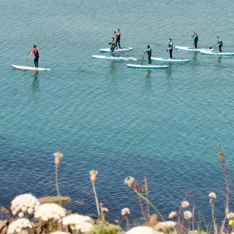 Paddleurs sur une eau turquoise