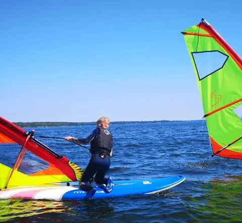 Deux élèves en planche à voile sur l'eau