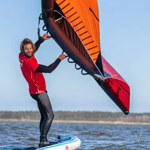 Moniteur en wingsurf avec une aile orange