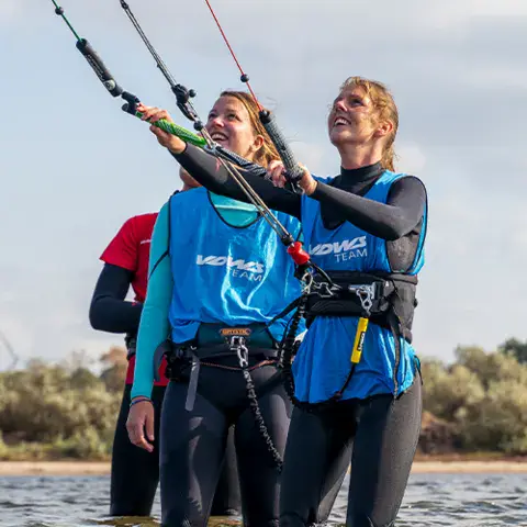 Cours de kitesurf dans l'eau, deux personnes avec leurs lignes