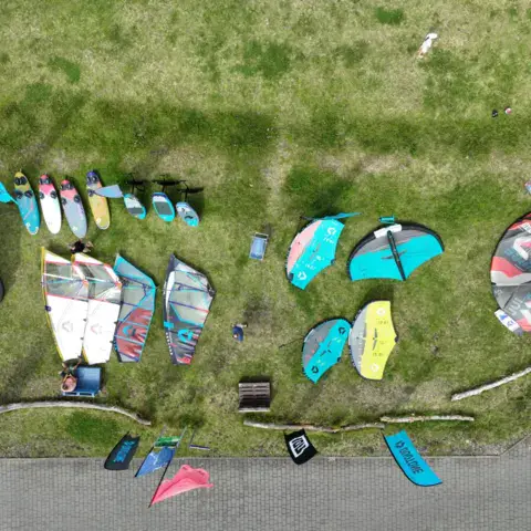 Vue aérienne de matériel étalé sur l'herbe au bord de l'eau