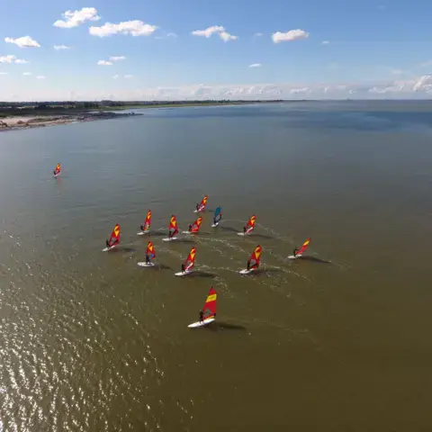 Vue aérienne de windsurfeurs en groupe sur l'eau