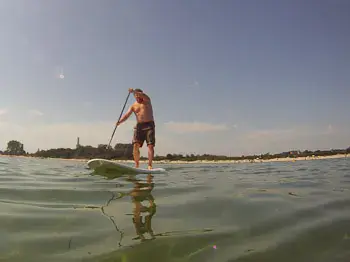 Pratiquant de stand up paddle sur l'eau calme
