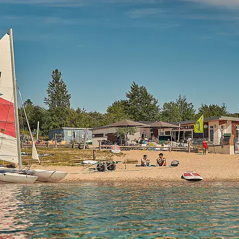 Un catamaran sur la plage, devant les cabanes du centre