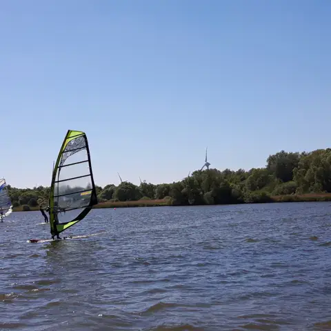 Plusieurs voiles de windsurf sur le lac