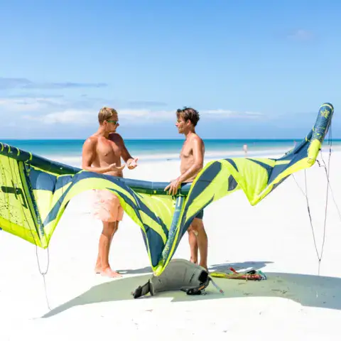 Préparation d'une aile de kite sur la plage