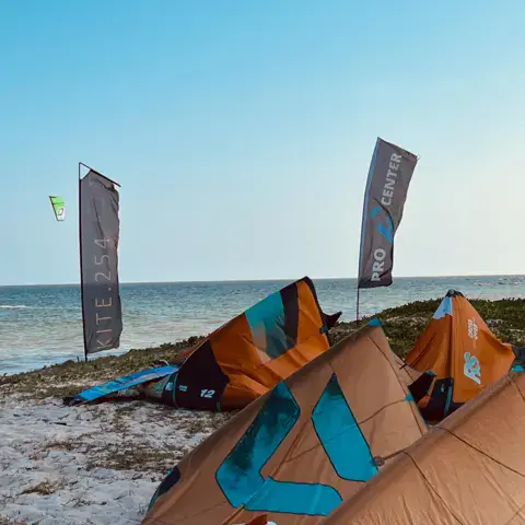 Ailes et planches de kite posées sur le sable