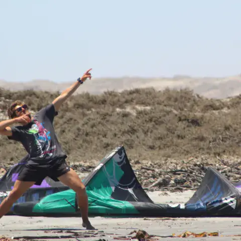Kite posé sur la plage, dunes en arrière-plan