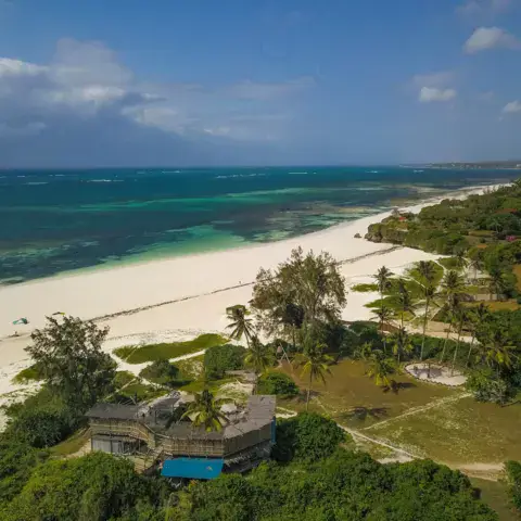 Vue aérienne de la plage de sable blanc et du village