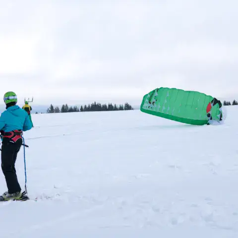 Un élève de snowkite en pleine préparation de son aile