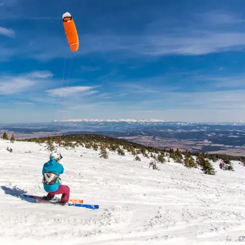 Un rider de snowkite sur une pente enneigée