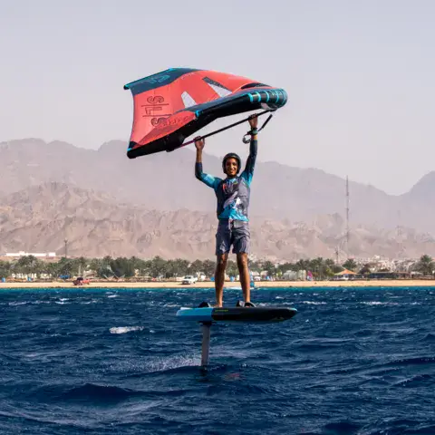 Un pratiquant de wing foil debout sur sa planche