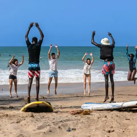 Échauffement collectif sur le sable avant le cours