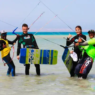 Élèves et moniteurs avec leurs planches dans l'eau