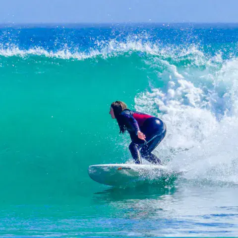 Surfeuse en virage sur une vague