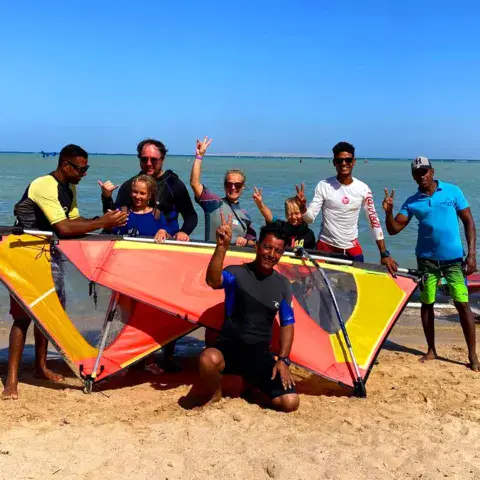 Groupe de windsurf sur la plage avec le matériel