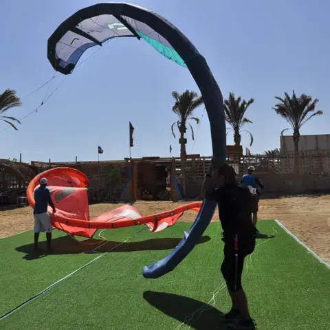 Préparation d'un kite sur la pelouse du centre