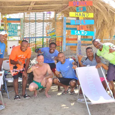 Un groupe de moniteurs et de kiters devant le bar de plage