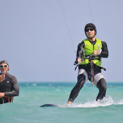 Un élève sur sa planche de kite, avec un moniteur à côté