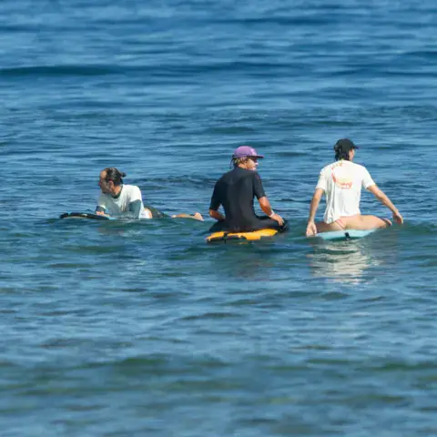 Groupe assis sur leurs planches au large
