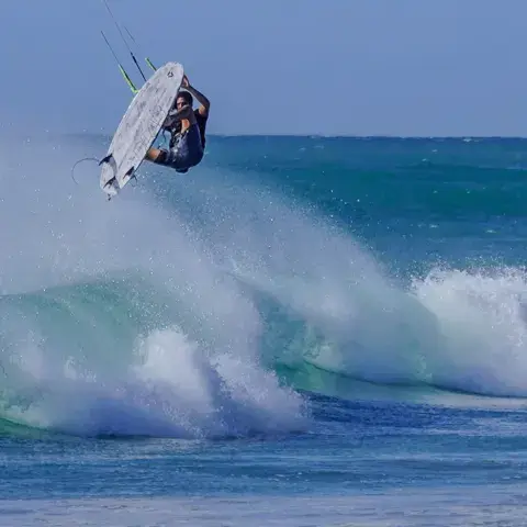 Un rider saute au-dessus d'une vague en kitesurf